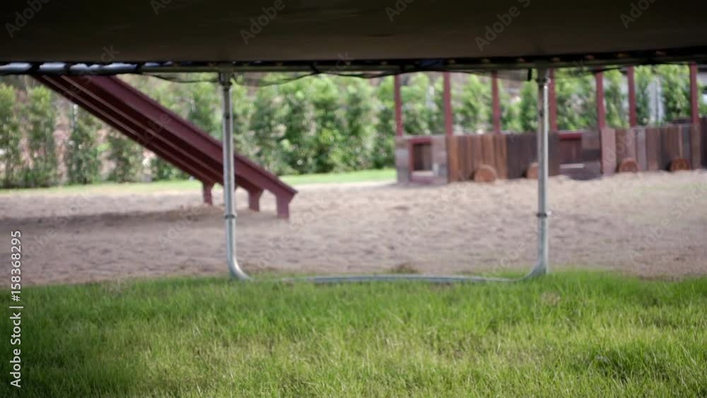 Bottom view of trampoline with jumping people in outdoor Bottom view of trampoline with jumping people in outdoor