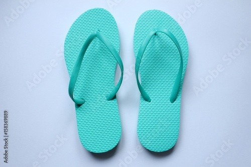Des paires de chaussures de plage tong en couleurs sur fond blanc