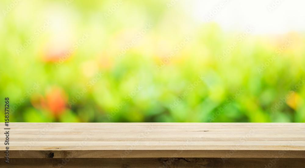 Empty of wood table top on blur of fresh green abstract from garden background.For montage product display or key visual layout Empty of wood table top on blur of fresh green abstract from garden background.For montage product display or key visual layout