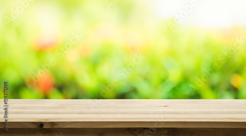 Empty of wood table top on blur of fresh green abstract from garden background.For montage product display or key visual layout