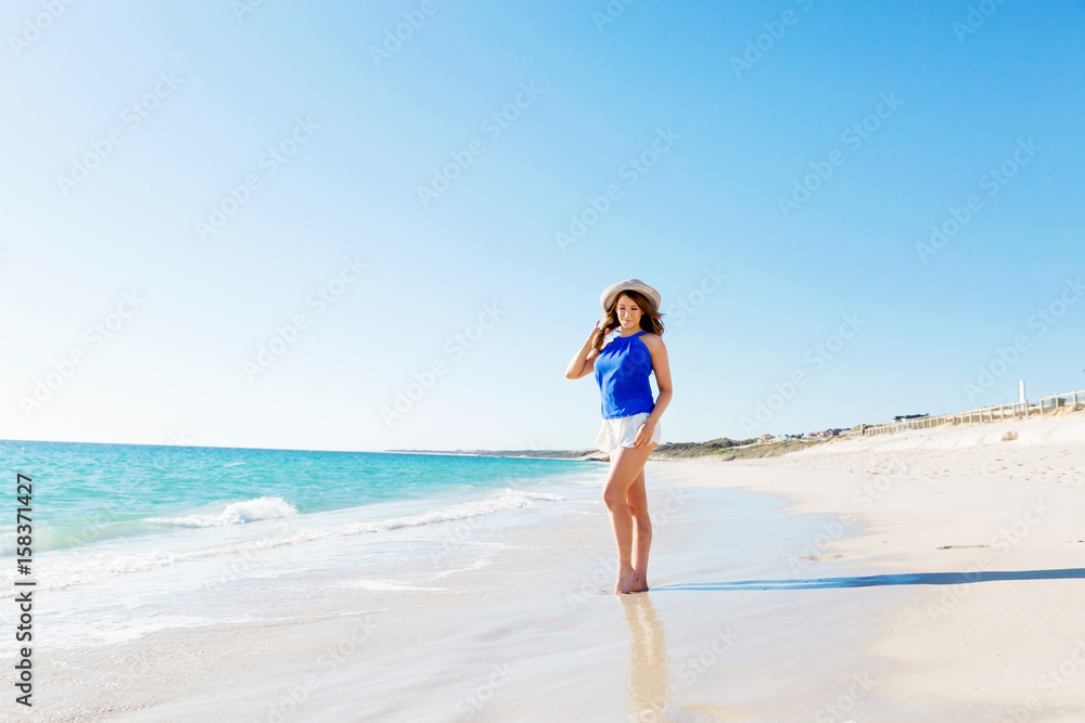 Young woman walking along the beach Young woman walking along the beach