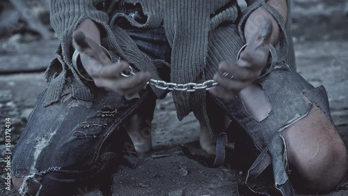 a prisoner in chains on his knees