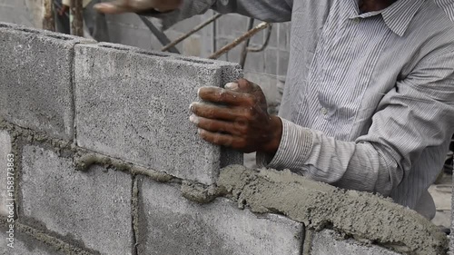 Bricklayer putting down another row of bricks in site.
