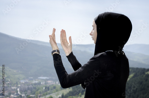 Young muslim women prayer standing on mountain