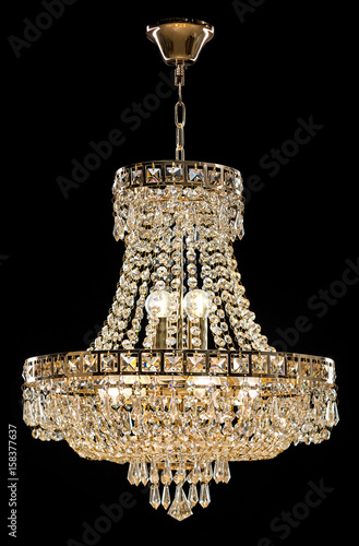 Large crystal chandelier isolated on black background.