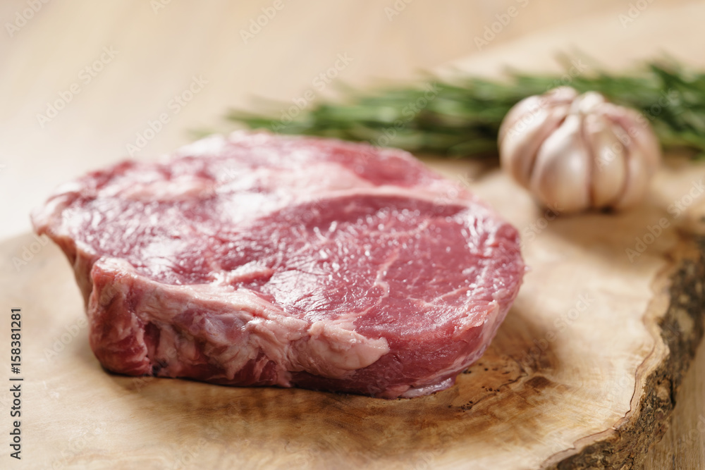 raw rib eye steak on board closeup, shallow focus raw rib eye steak on board closeup, shallow focus