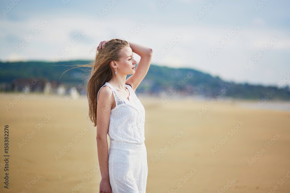 Beautiful young woman enjoying sun on a sand beach Beautiful young woman enjoying sun on a sand beach