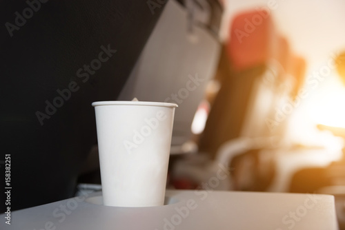Drink in a glass of white paper on the plane.