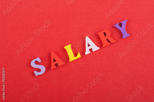 SALARY word on red background composed from colorful abc alphabet block wooden letters, copy space for ad text. Learning english concept.