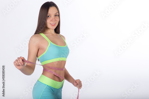 Female athlete poses with centimeter tape on waist © lenblr
