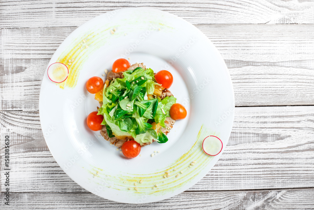 Fresh salad with chicken breast, baby spinach, lettuce, cherry tomatoes and cheese on wooden background close up Fresh salad with chicken breast, baby spinach, lettuce, cherry tomatoes and cheese on wooden background close up