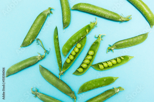 Pods of green peas on a blue background.