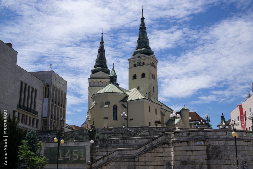 Building, Church and town during sunny day with clouds on sky. Slovakia