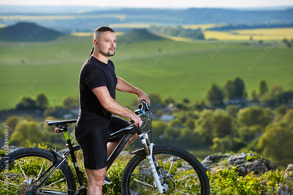 Close-up portrait of the mountain biker looking at beautiful landscape.