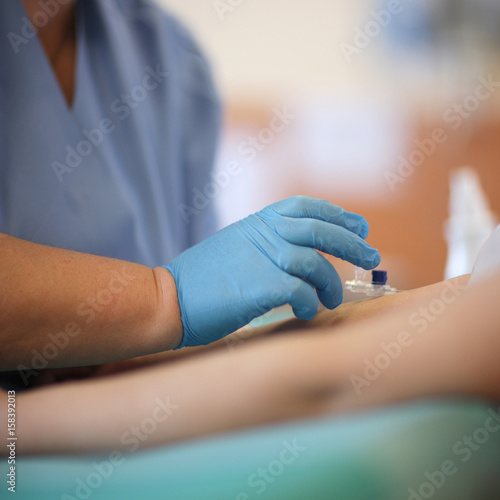 An anesthesiologist inserts a catheter into the patient's arm before surgery