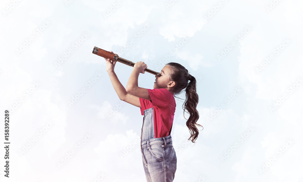 Concept of careless happy childhood with girl looking in spygl Concept of careless happy childhood with girl looking in spygl