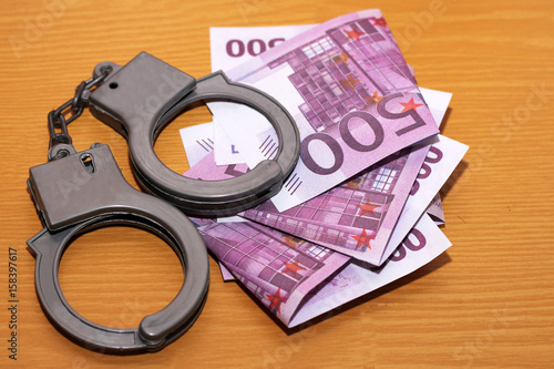 Handcuffs and euro money. Punishment and crime.