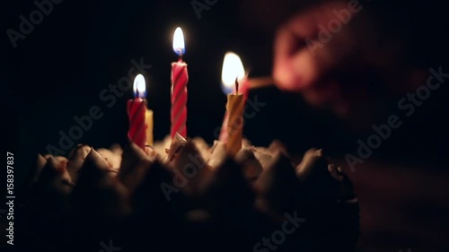 Light the candles on the cake, birthday boy makes a wish and blows out the candles on the cake in the dark