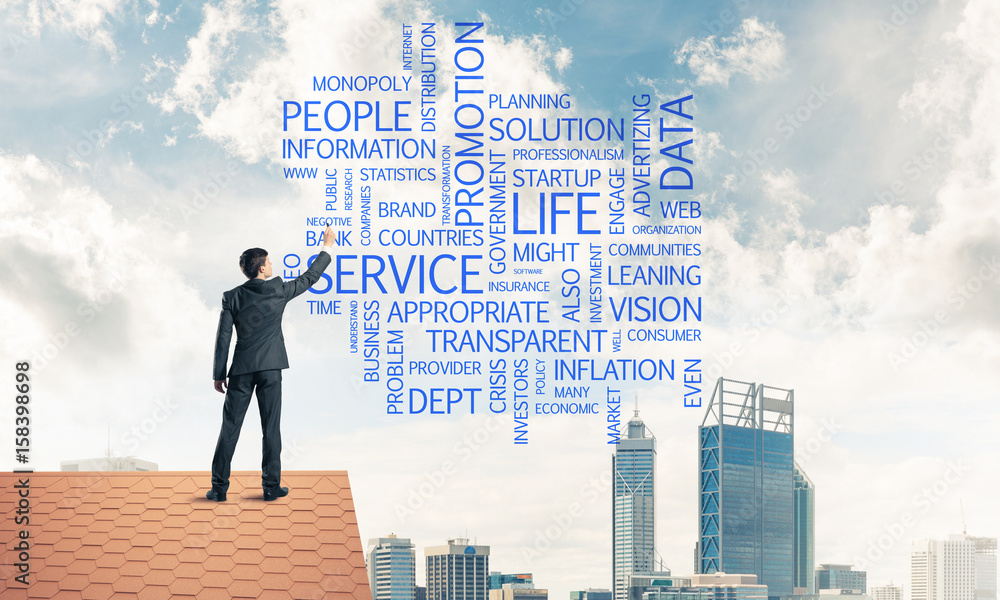Young businessman standing on house roof and writing leadership Young businessman standing on house roof and writing leadership