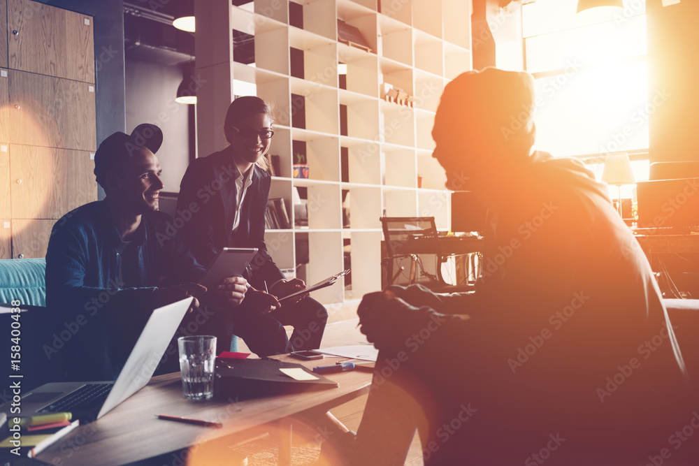 Group of young business people have meeting in big office. New ideas brainstorming. Three persons. Intentional sun glare and lens flares Group of young business people have meeting in big office. New ideas brainstorming. Three persons. Intentional sun glare and lens flares