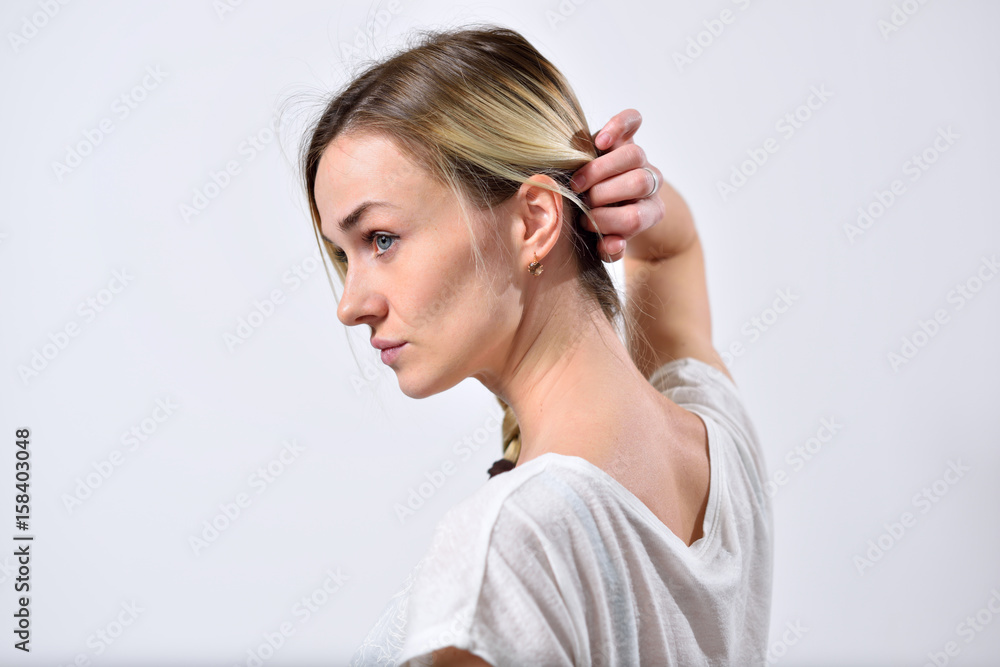 Fototapeta premium Blond girl showing ear and neck pulling back hair