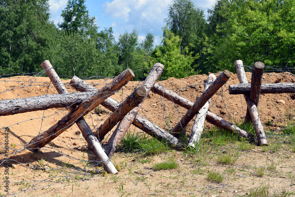 Fototapeta premium Drut kolczasty wraz z okopami. Wojna.