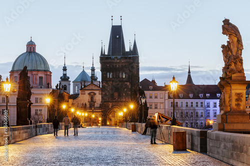 Charles bridge, twilight scenery, street lights visible. Prague iconic travel destination, Czech Republic.