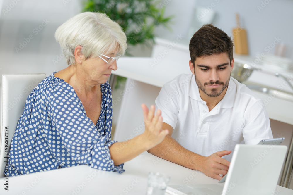 Young man and senior lady looking at tablet Young man and senior lady looking at tablet