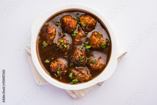 Gobi Manchurian dry or with gravy - Popular street food of India made of cauliflower florets, selective focus photo