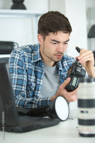 Young man repairing camera