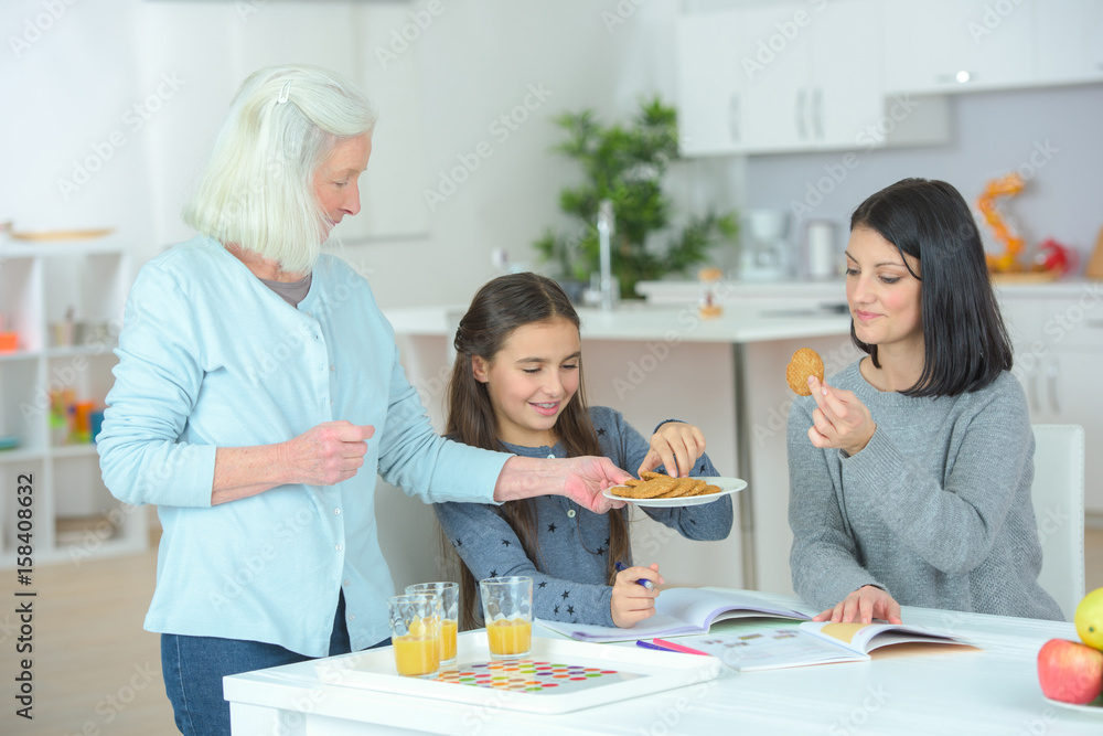 Elderly lady serving biscuits to young girls