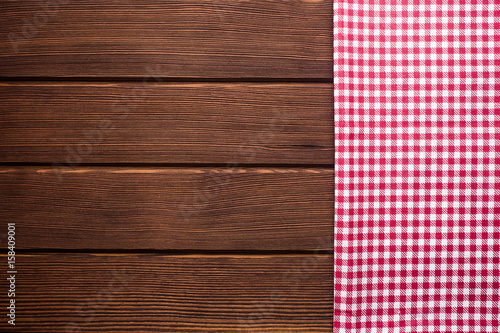 Napkin in a red and white cage on a wooden background, texture, copy space