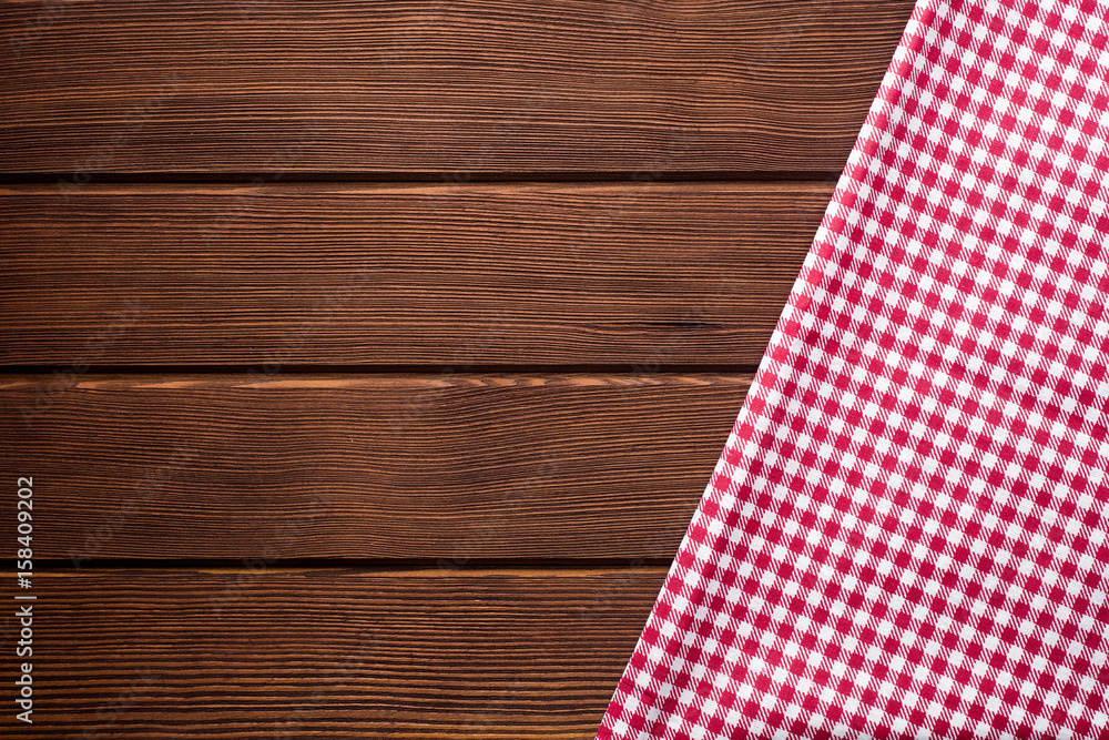 Obraz premium Napkin in a red and white cage on a wooden background, texture, copy space