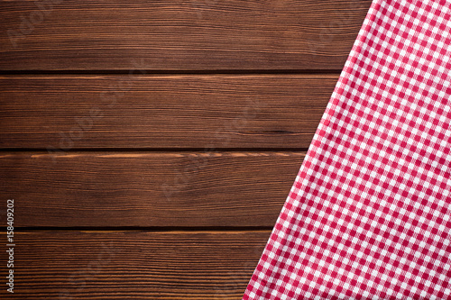 Napkin in a red and white cage on a wooden background, texture, copy space