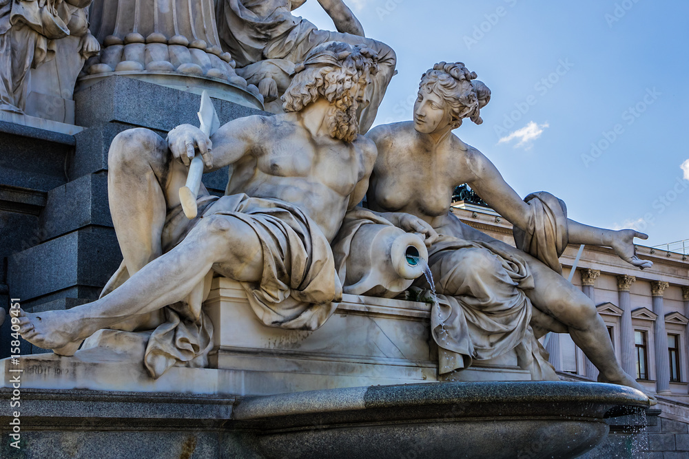 Naklejka premium Fragments of the Pallas Athena (goddess of wisdom) fountain, in front of the Austrian Parliament Building. The figures symbolize the rivers Danube, Inn, Elbe and Moldau. Vienna, Austria, Europe.