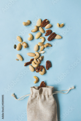 Fototapeta Naklejka Na Ścianę i Meble -  Nuts mix. Cashews, almonds and pecans on the blue background, top view