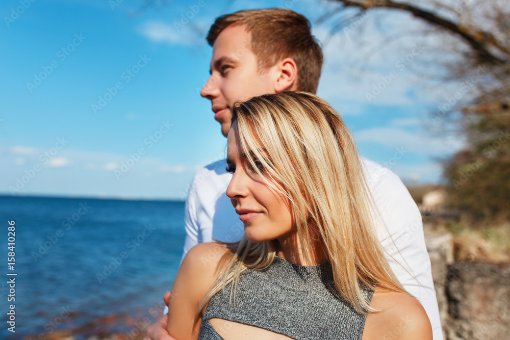 Happy couple on sea background. Happy young couple laughing and hugging on the beach Happy couple on sea background. Happy young couple laughing and hugging on the beach