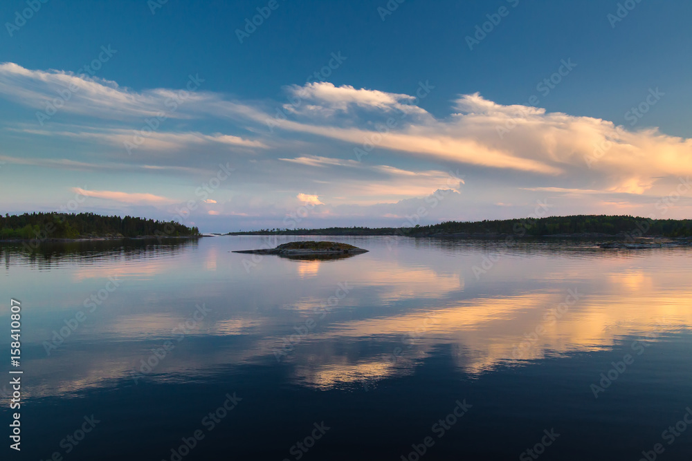 Reflection of clouds to water. Evening sky. Sunset over the water. White Nights. Karelia. Ladoga lake.