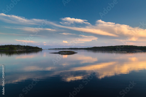 Reflection of clouds to water. Evening sky. Sunset over the water. White Nights. Karelia. Ladoga lake.