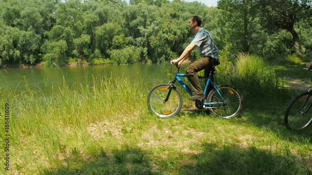 Active family on bicycles. Cyclists by the river. Active family on bicycles. Cyclists by the river.