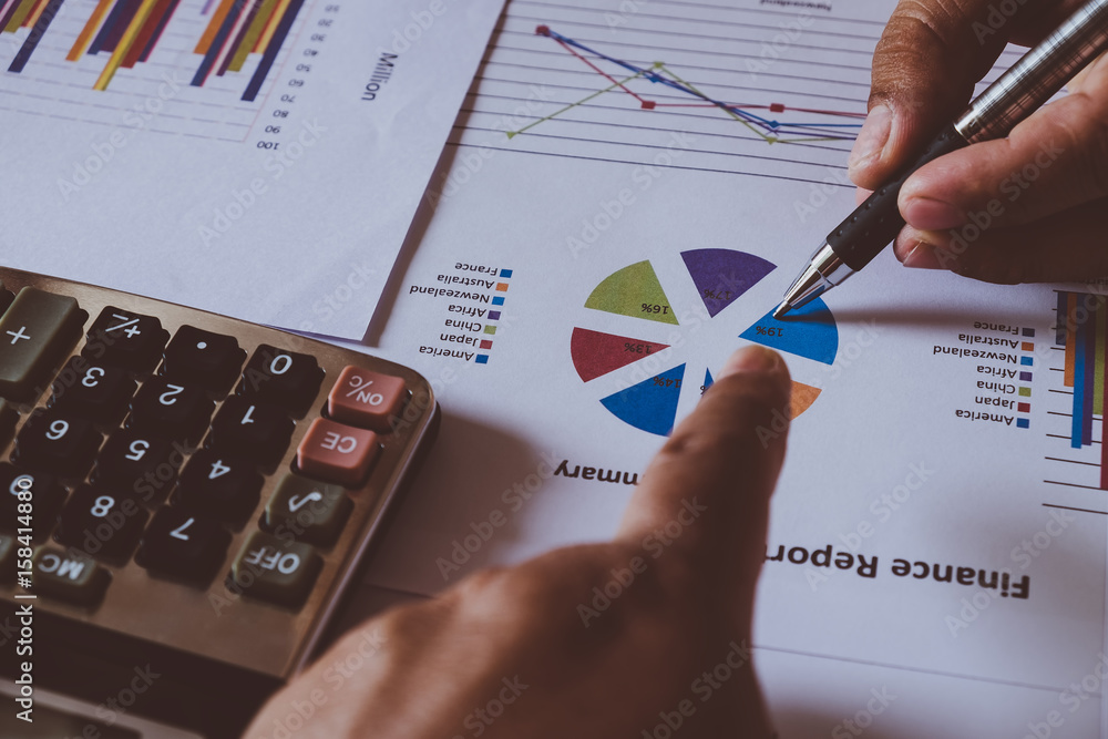 male hands pointing at turnover graph while discussing it on wooden desk in office. group support concept. male hands pointing at turnover graph while discussing it on wooden desk in office. group support concept.
