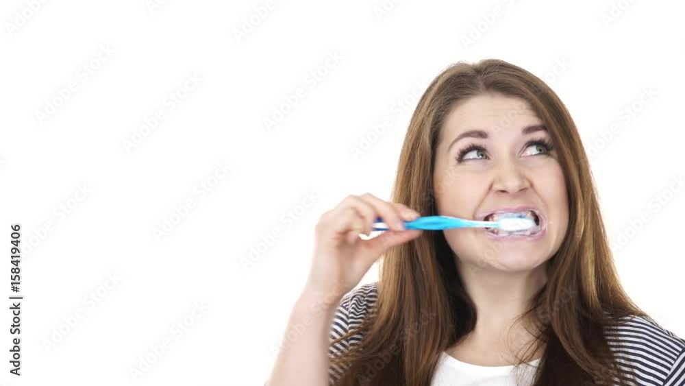 Woman dark long hair brushing cleaning teeth. Positive girl with toothbrush. Oral hygiene. Studio shot isolated on white background 4K ProRes HQ codec Woman dark long hair brushing cleaning teeth. Positive girl with toothbrush. Oral hygiene. Studio shot isolated on white background 4K ProRes HQ codec