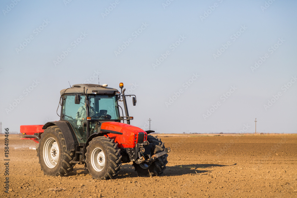 Farmer fertilizing arable land with nitrogen, phosphorus, potassium fertilizer Farmer fertilizing arable land with nitrogen, phosphorus, potassium fertilizer