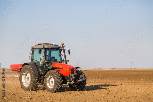 Farmer fertilizing arable land with nitrogen  phosphorus  potassium fertilizer