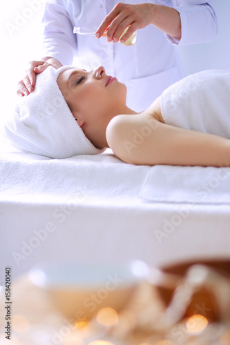 Young woman lying on a massage table,relaxing with eyes closed