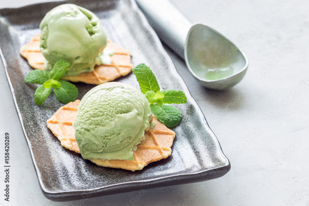 Matcha green tea ice cream balls served with waffles on black plate, horizontal, copy space Matcha green tea ice cream balls served with waffles on black plate, horizontal, copy space