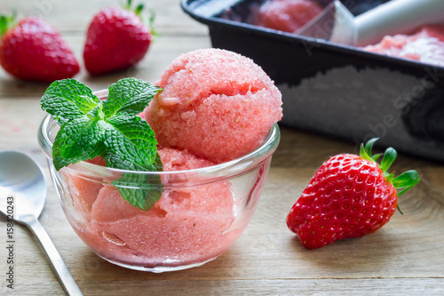 Homemade strawberry sorbet in glass on a wooden table