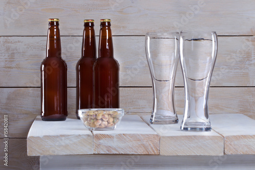 Пивные бокалы и бутылки с пивом на столе