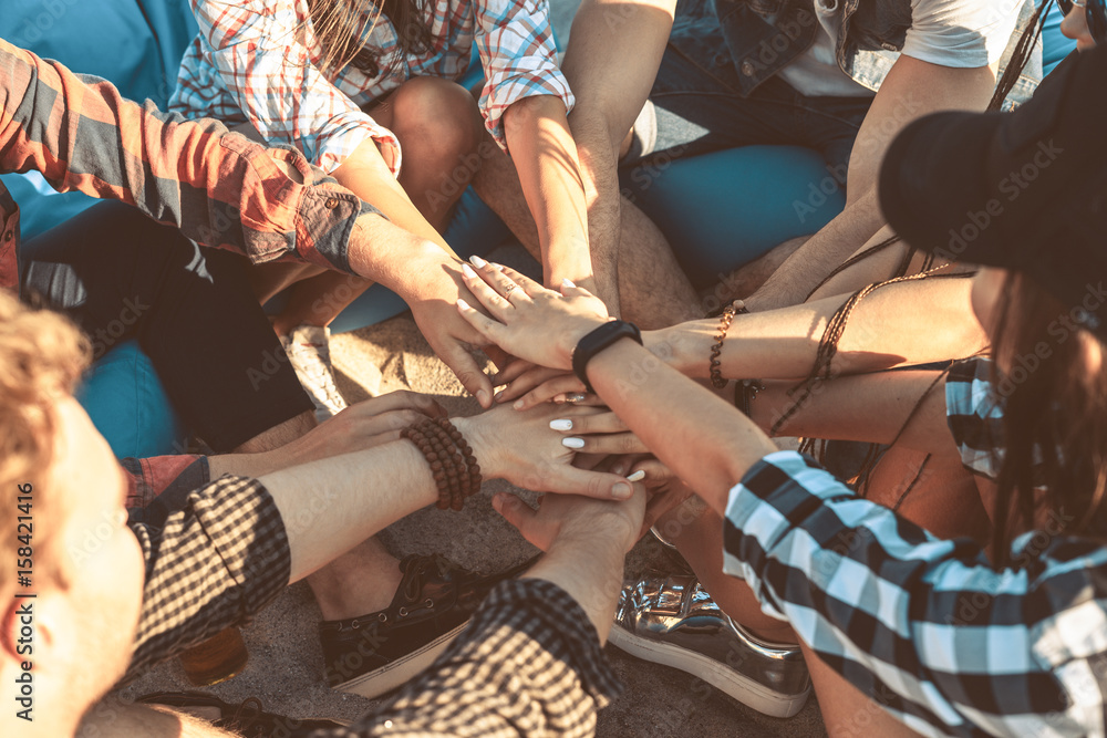 Fototapeta premium Closeup view of happy friends putting hands on hands Friendship concept. stack of hands together. view from above