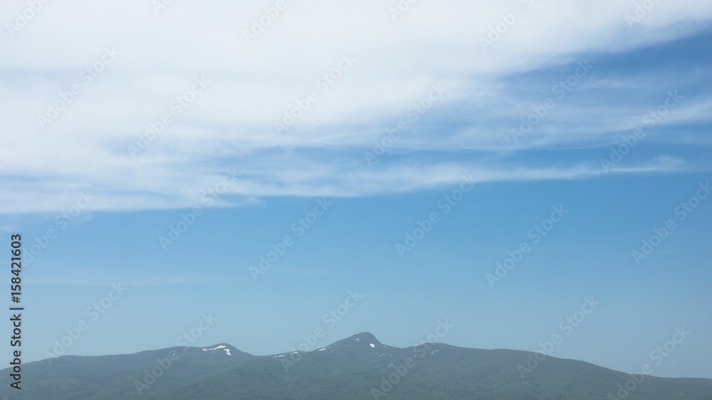 残雪の残る山頂　高い雲　北海道昆布岳